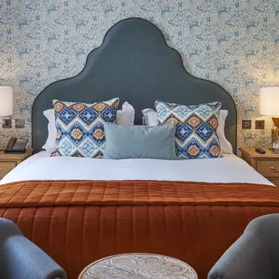 Bedroom featuring a comfortable bed and two chairs.