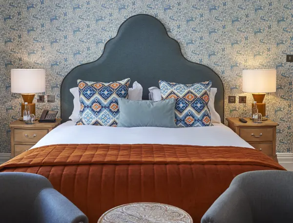 Bedroom featuring a comfortable bed and two chairs.