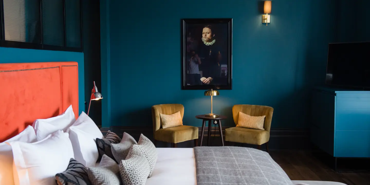 Bedroom featuring blue walls and a wall painting.