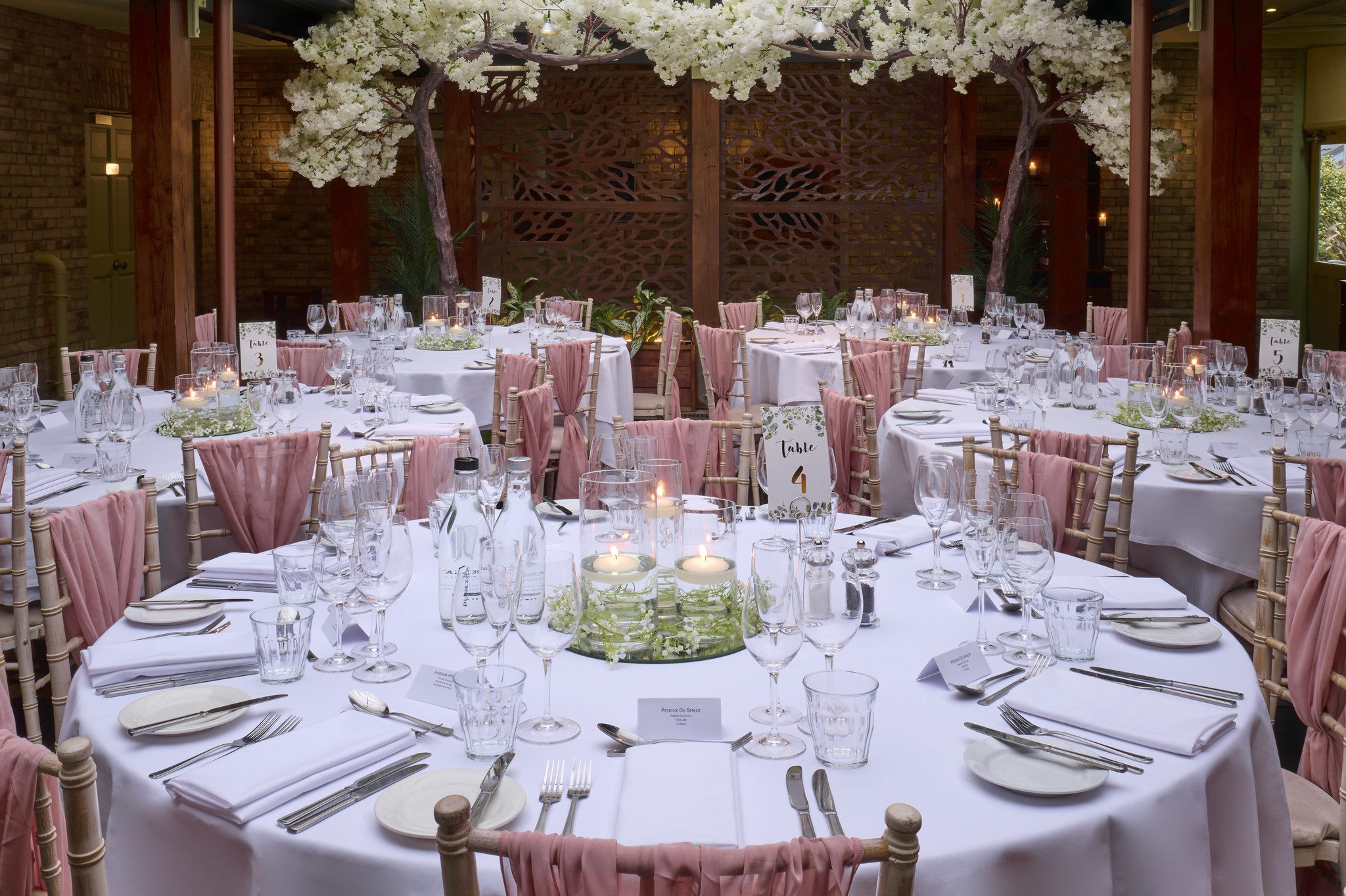 A room furnished with tables, chairs, and adorned with flowers.