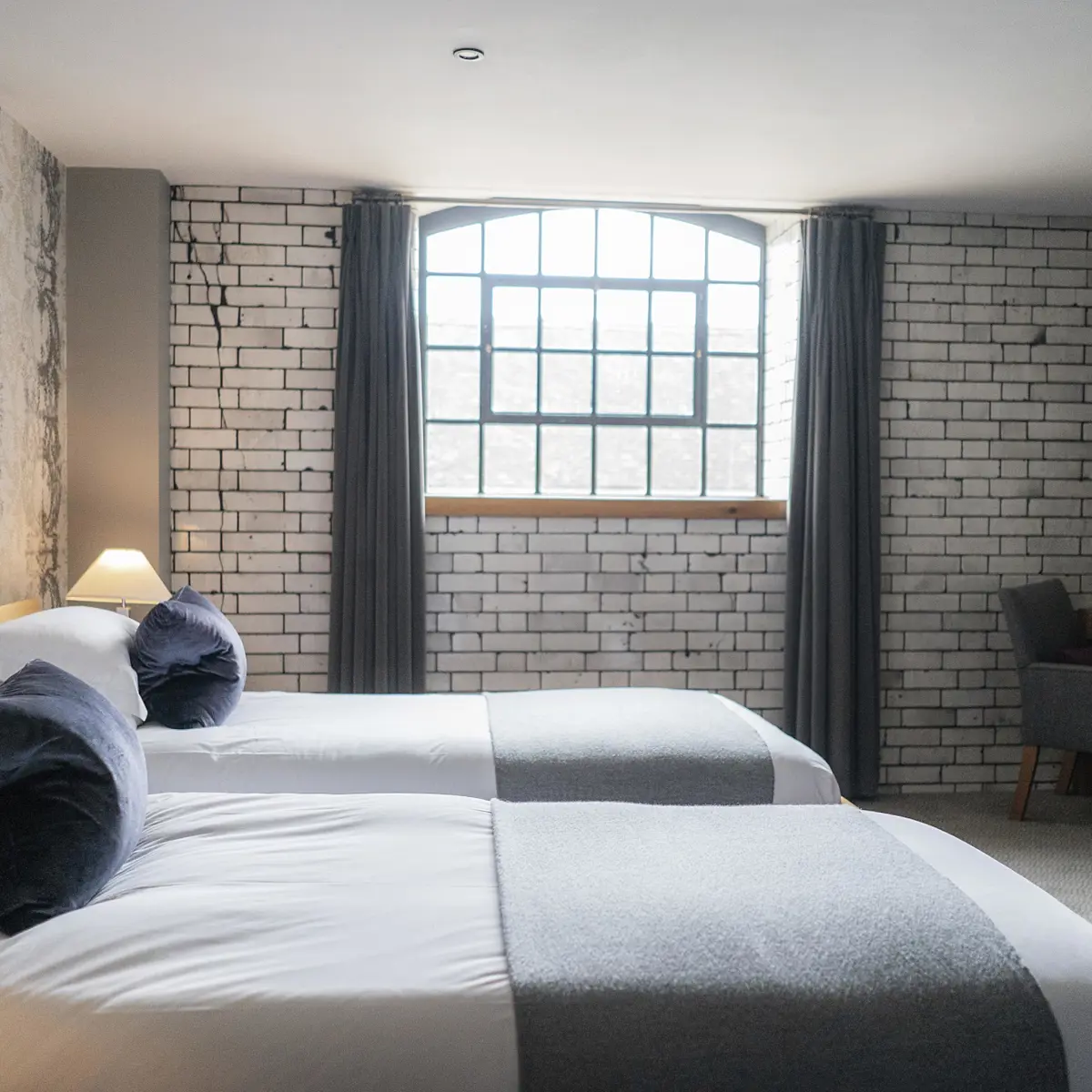 Spacious hotel room featuring two comfortable beds and a functional desk.