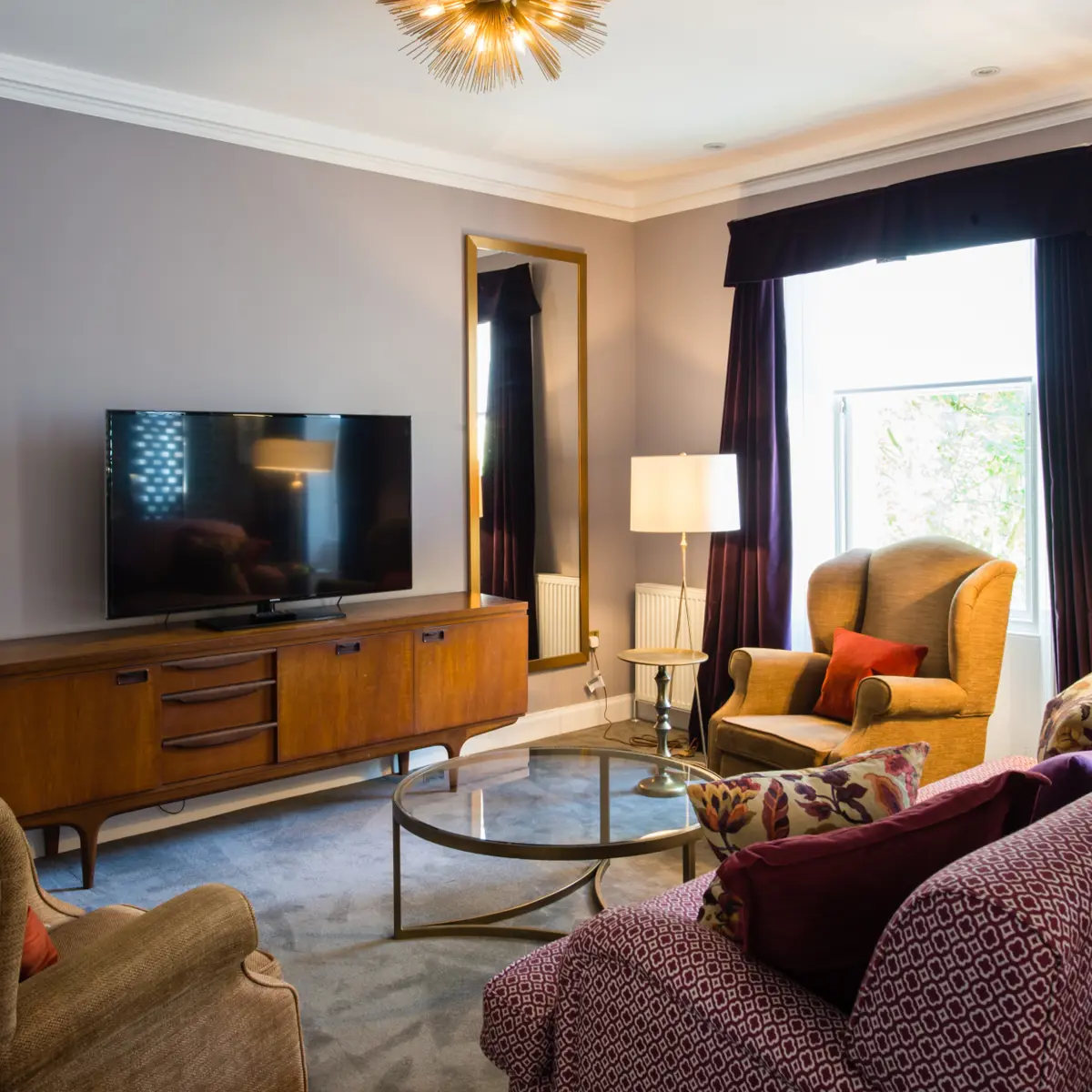 A well-furnished living room featuring a flat-screen TV.