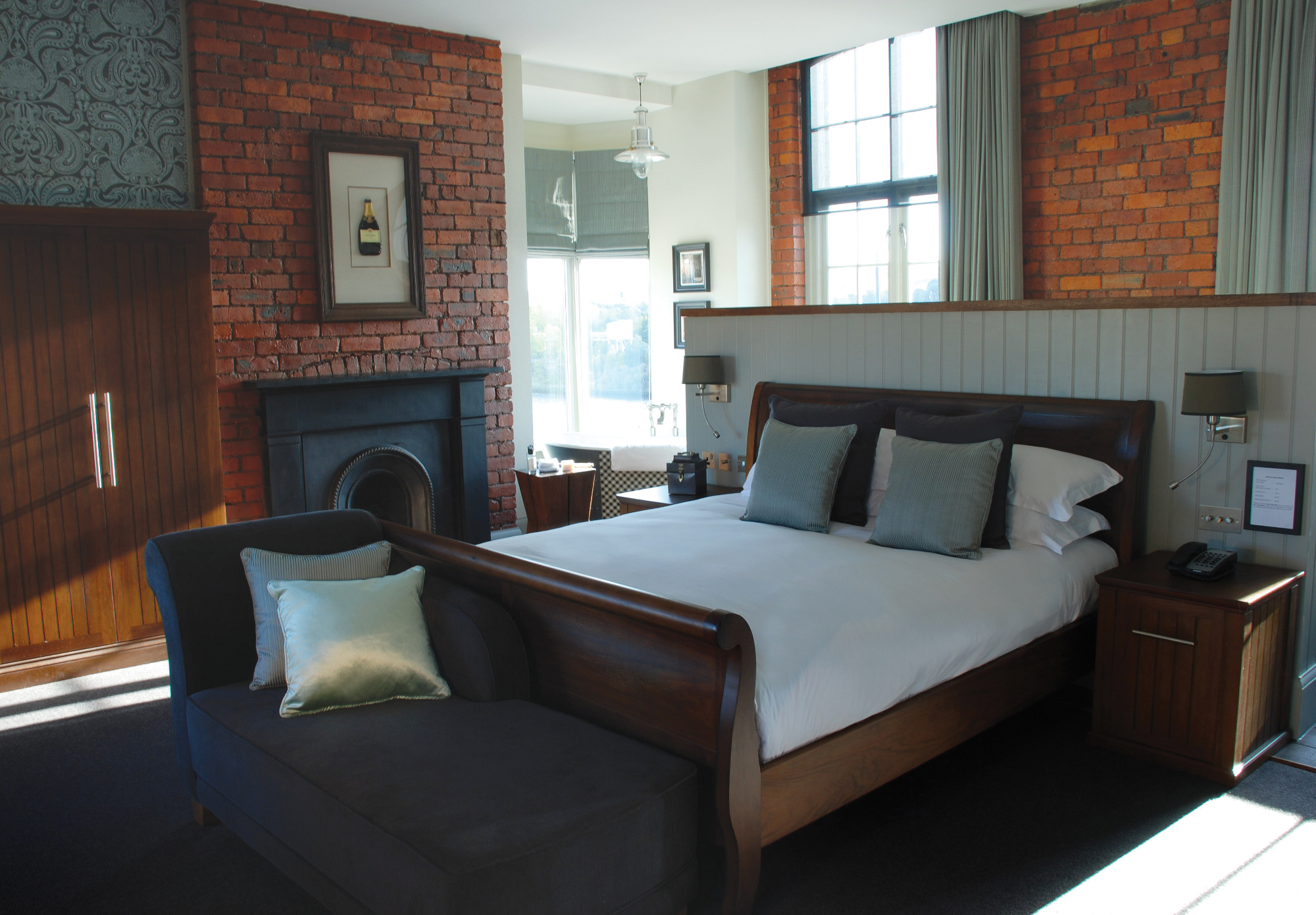 Bed positioned alongside a fireplace in a bedroom.