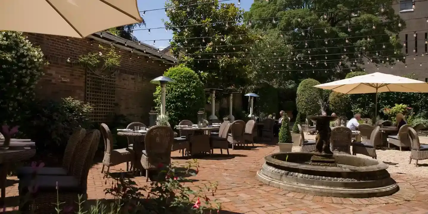 A patio featuring tables, chairs, and umbrellas.