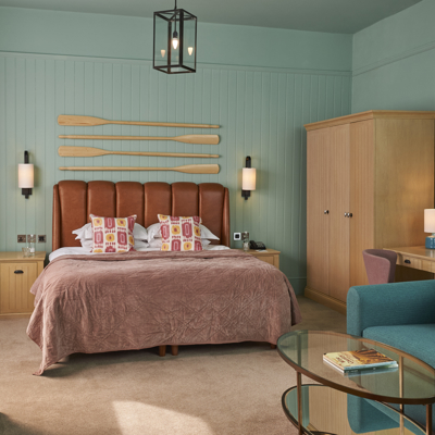 Spacious bedroom featuring a king-sized bed and an elegant chair.