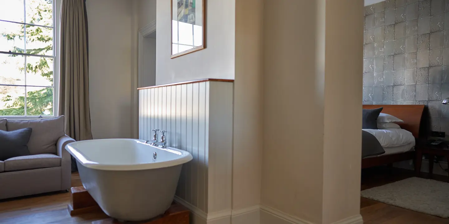 Bathtub and couch in a bathroom.