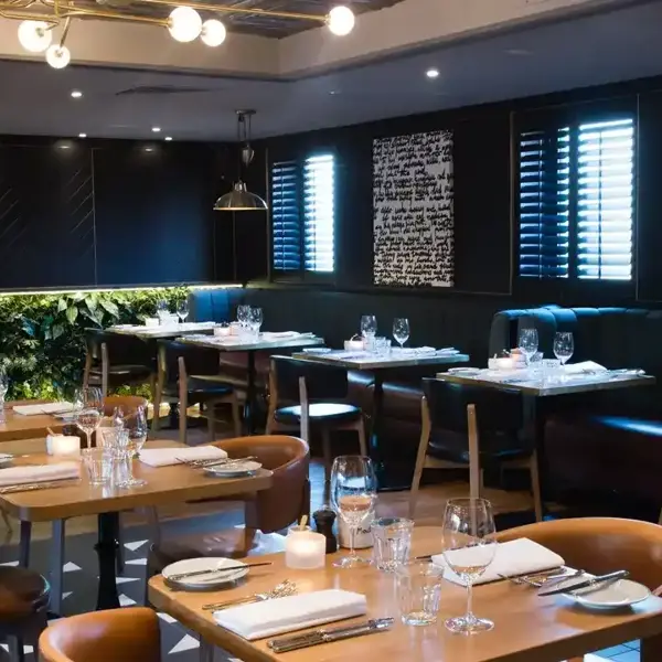 A restaurant featuring tables, chairs, and a bar.