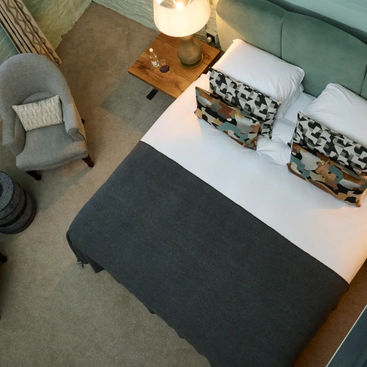 An elegantly furnished hotel room featuring a comfortable bed, spacious desk, and cozy chair.