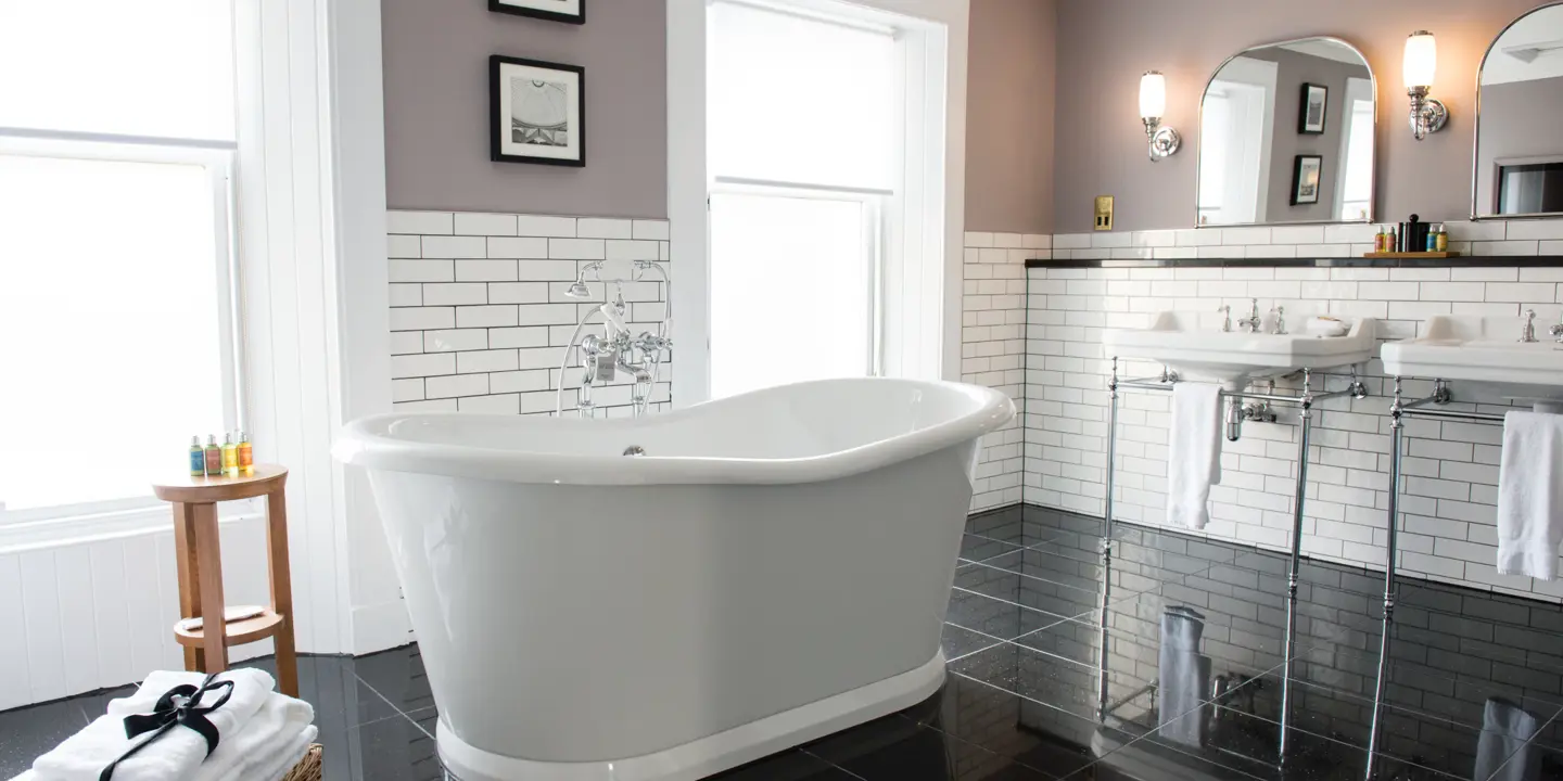 White bathtub positioned in a bathroom adjacent to a window.