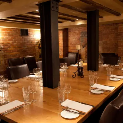 Wooden table with neatly arranged place settings.