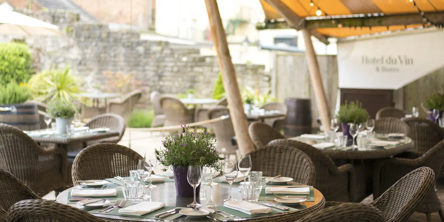 Table set with place settings under a tent.