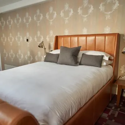 Bedroom featuring a generously-sized bed with an elegant brown headboard.