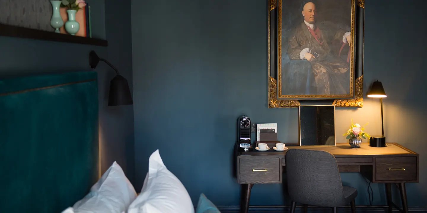 A well-arranged bedroom featuring a neatly made bed and an art piece adorning the wall.