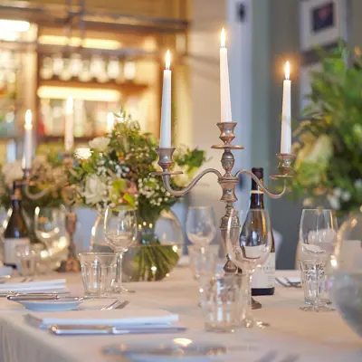 Table set for a formal dinner with candles and flowers.