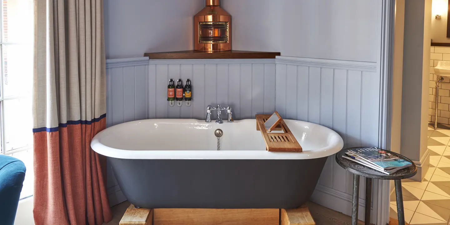 Bathtub in a bathroom next to a window.