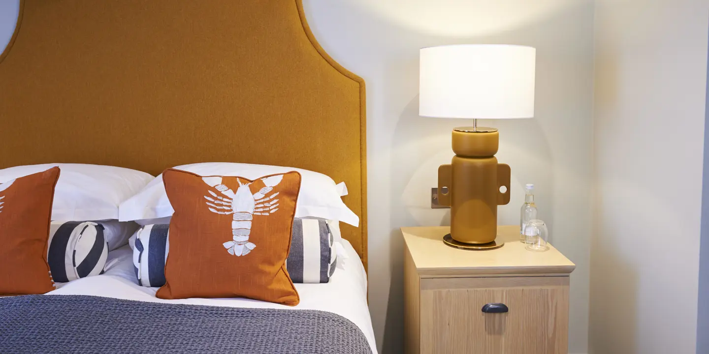 Neatly arranged bedroom with a well-made bed and nightstand.