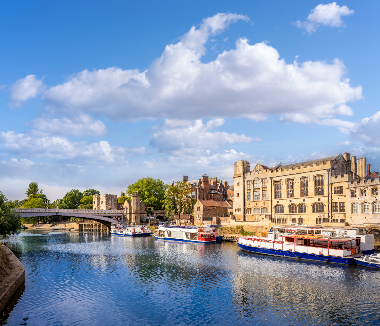 Several boats peacefully floating on a serene river.