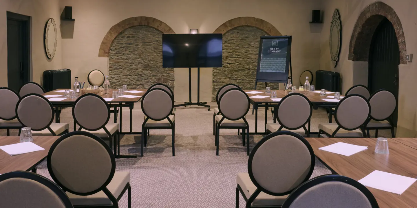 A meeting room featuring a long spacious table and chairs.