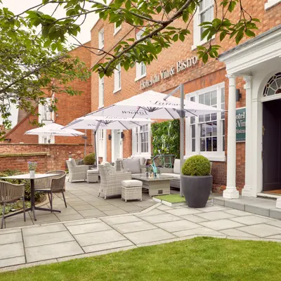 A patio area featuring tables, chairs, and umbrellas.