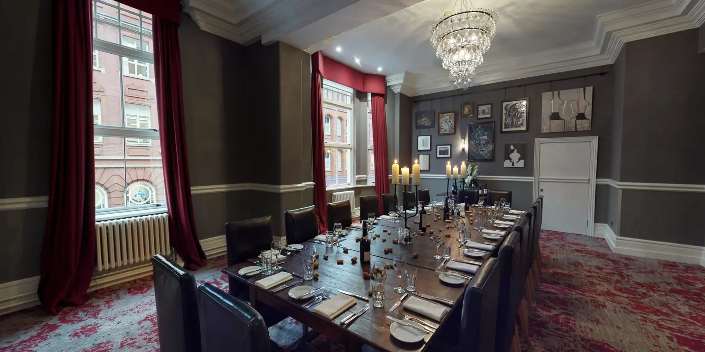 A dining room featuring a lengthy table adorned with an elegant chandelier.