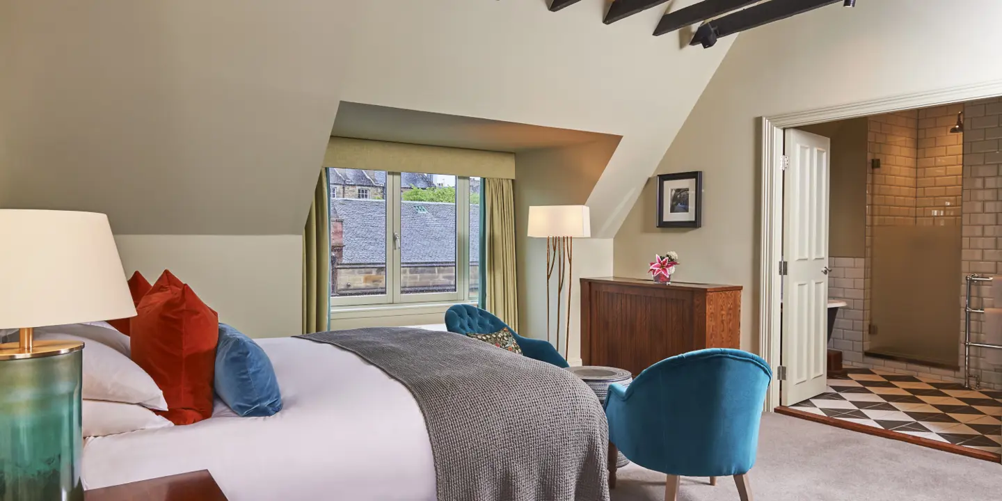 An elegant bed positioned in a well-lit bedroom beside a window.