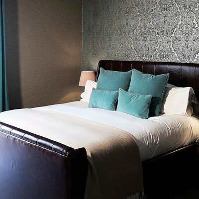 Bedroom featuring a comfortable bed and a stylish nightstand.