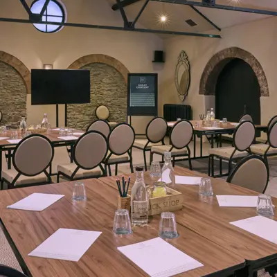 A meeting room featuring a spacious table and chairs.