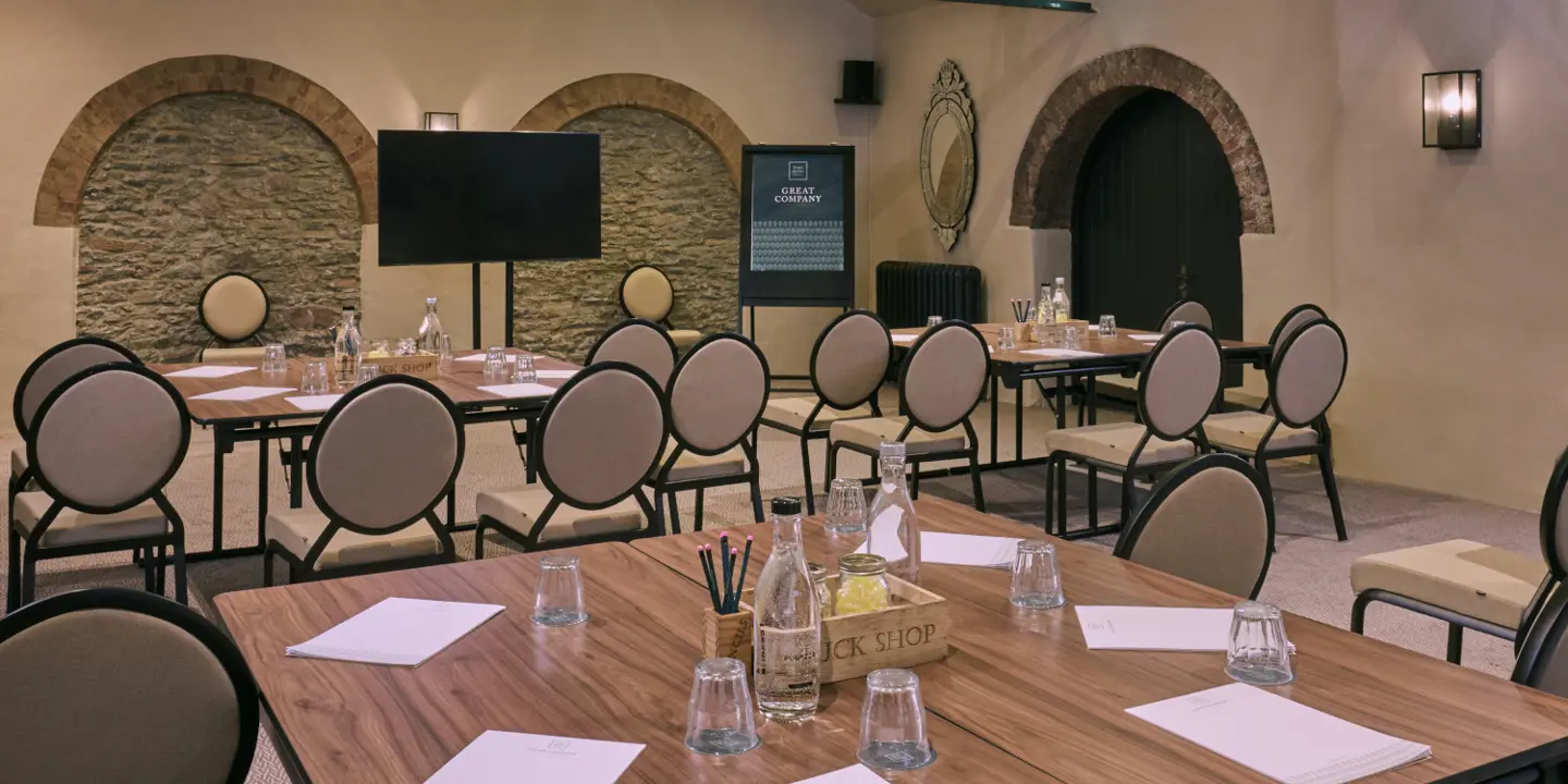 A meeting room featuring a spacious table and chairs.