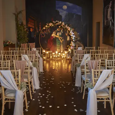 A room adorned with neatly arranged white chairs draped in elegant sashes.