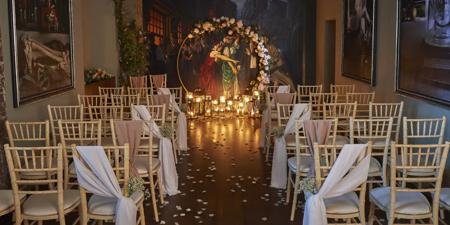 A room adorned with neatly arranged white chairs draped in elegant sashes.