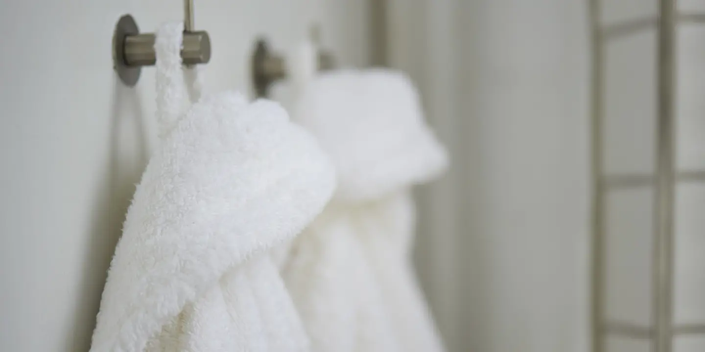 White dressing gowns hanging on a wall.