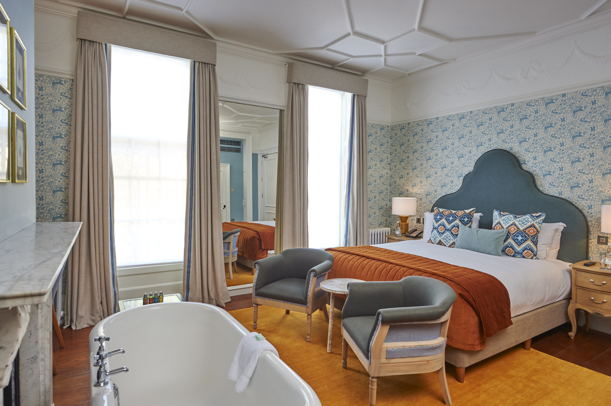 Bedroom featuring a comfortable bed, chair, and bathtub.