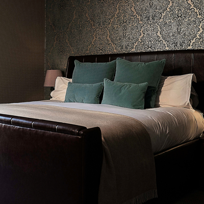 Bedroom featuring a comfortable bed and a stylish nightstand.