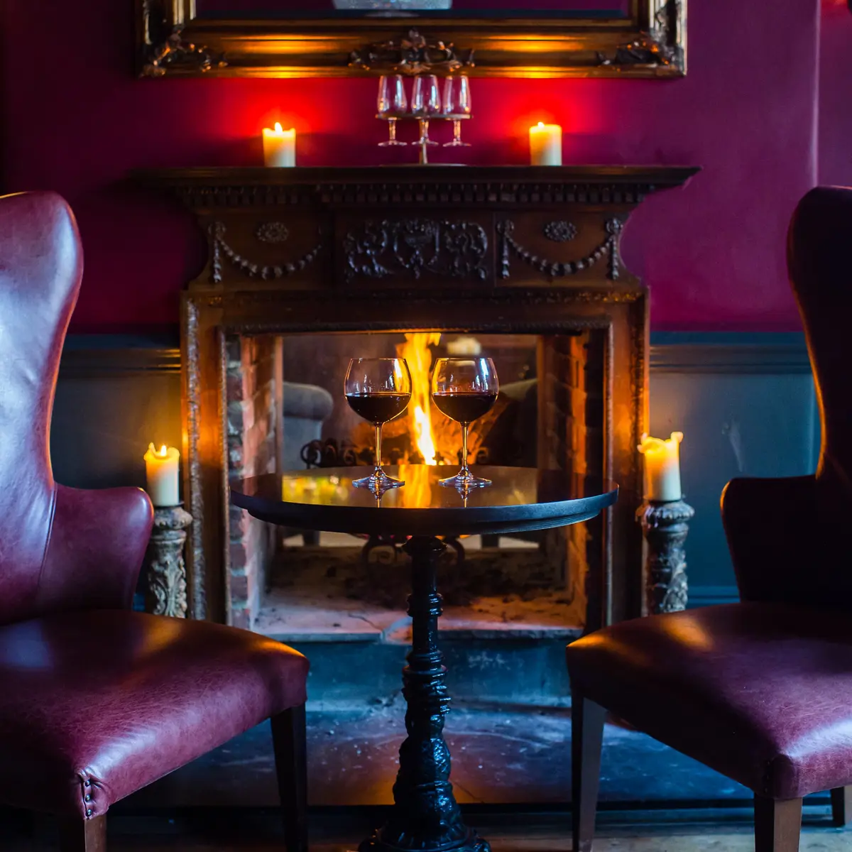 Two chairs positioned in front of a cozy fireplace.