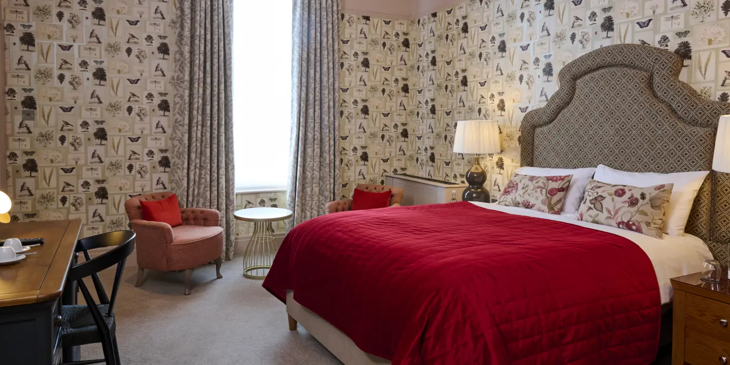 A neutral bedroom with a double bed in the centre