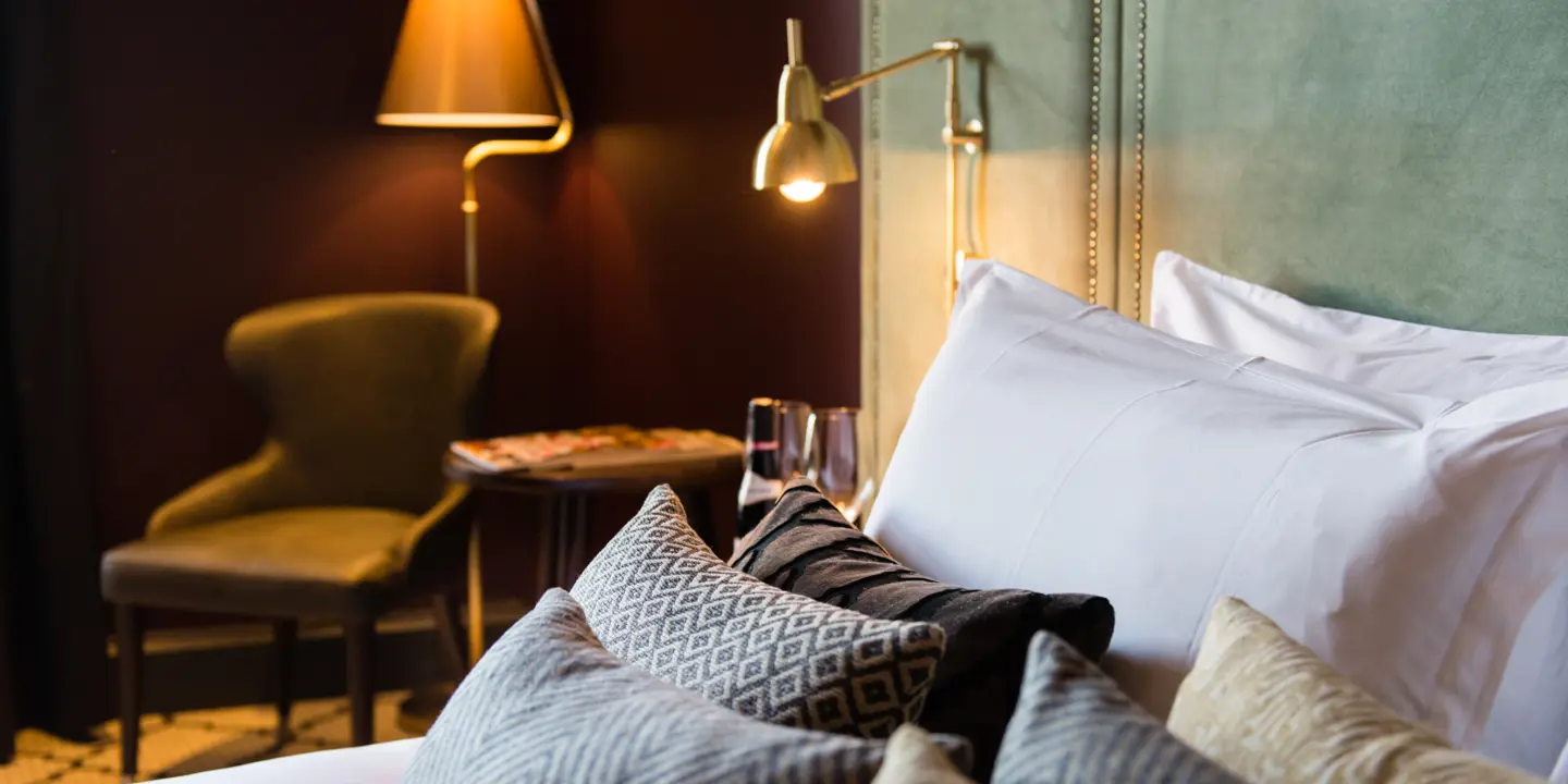 Green headboard and pillows on a bed.