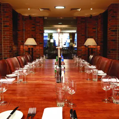 A wooden table adorned with wine glasses and silverware, creating an elegant setting.