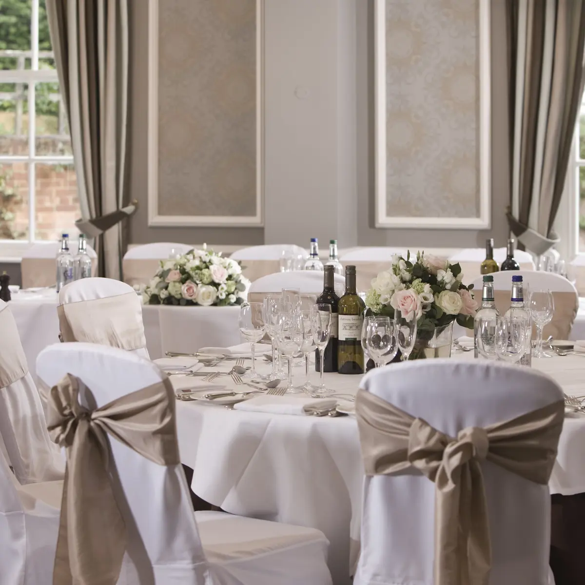 Table arranged for a wedding reception with wine bottles and glasses.