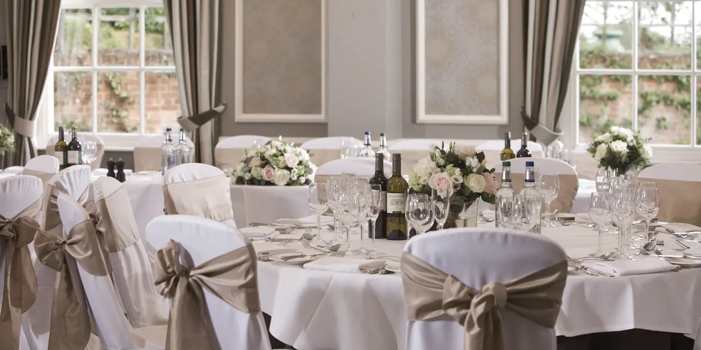 Table arranged for a wedding reception with wine bottles and glasses.