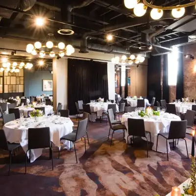 A spacious room with neatly arranged tables and chairs.