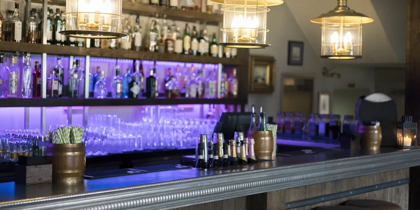 An assortment of bottles displayed on shelves in a bar.