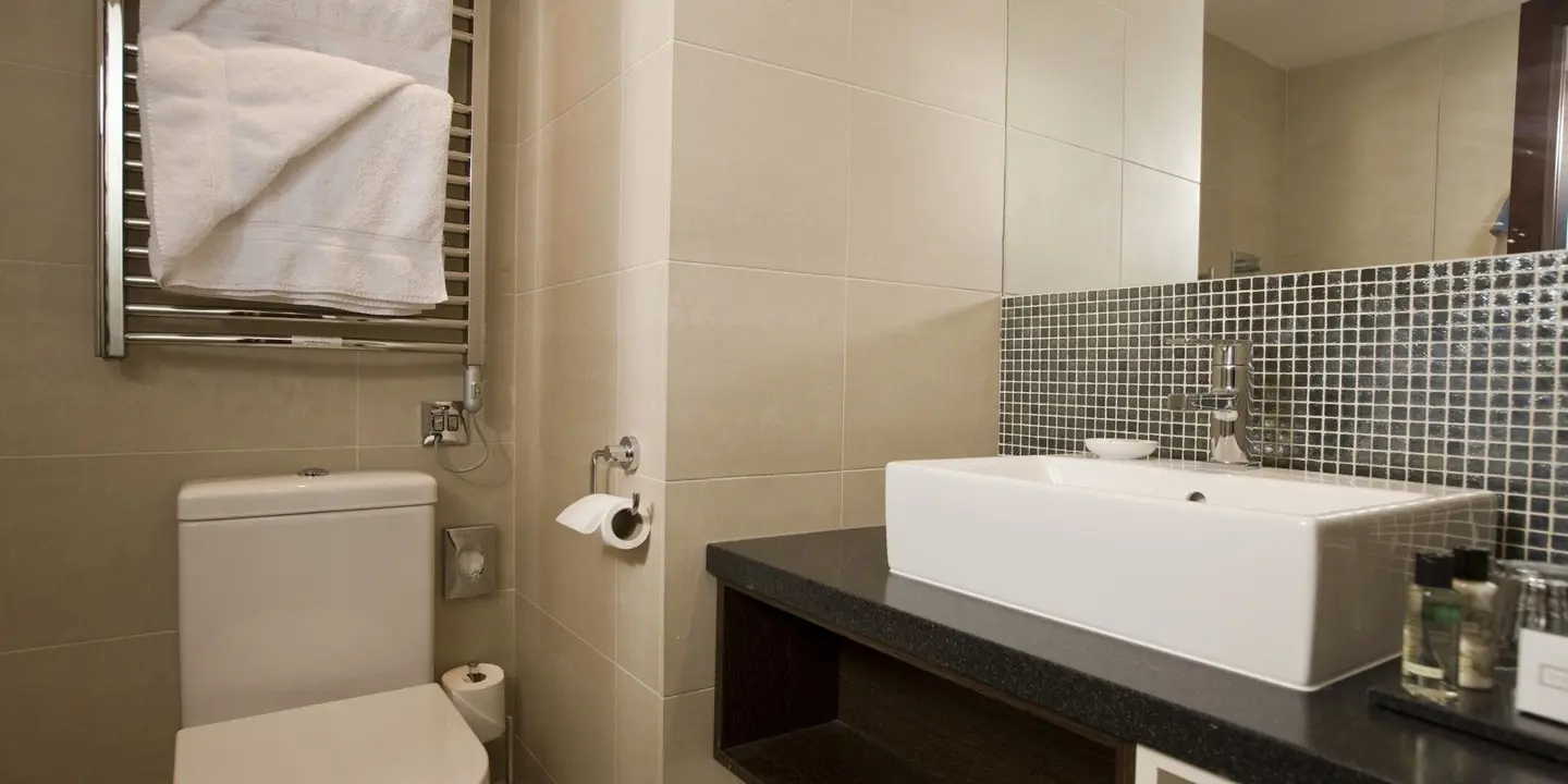 Bathroom featuring a sink, toilet, and towel rack.