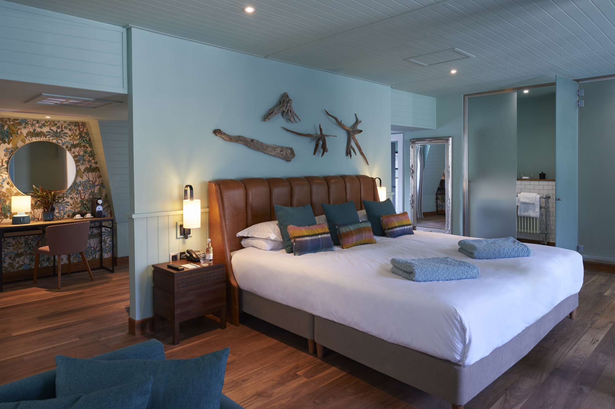 Spacious bedroom featuring a king-sized bed and an elegant chair.