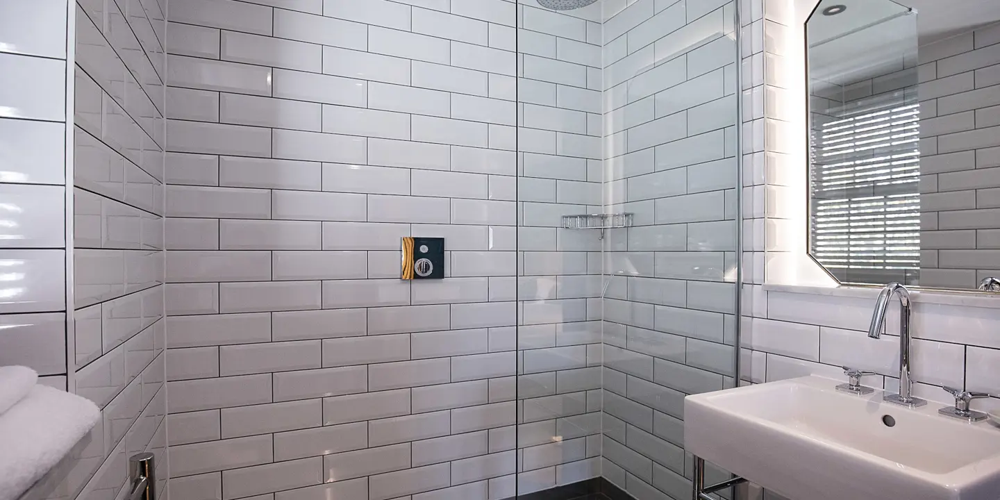 Bathroom featuring a shower, sink, and mirror.