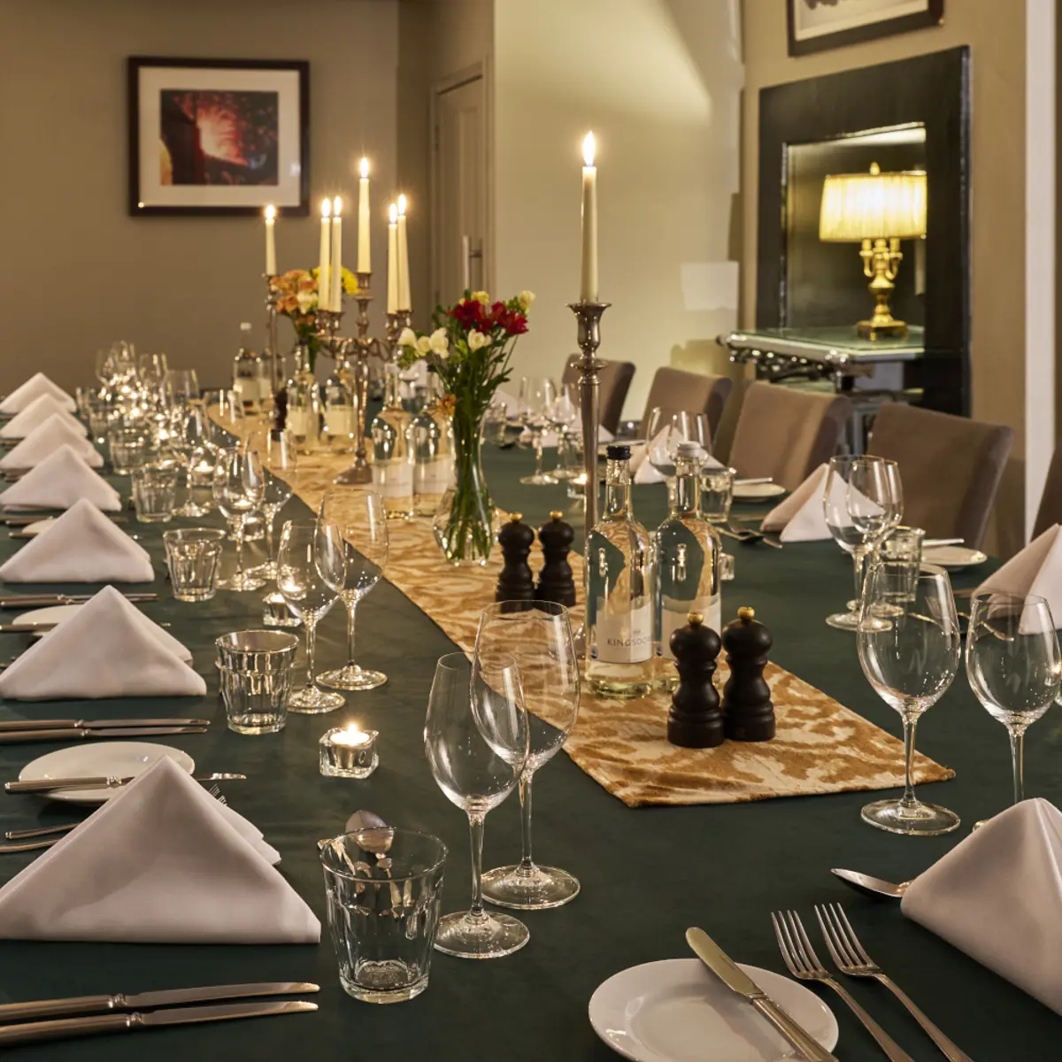 A wooden table adorned with wine glasses and neatly arranged place settings.