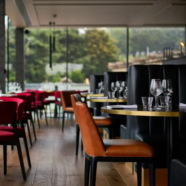 A restaurant featuring numerous tables and chairs.