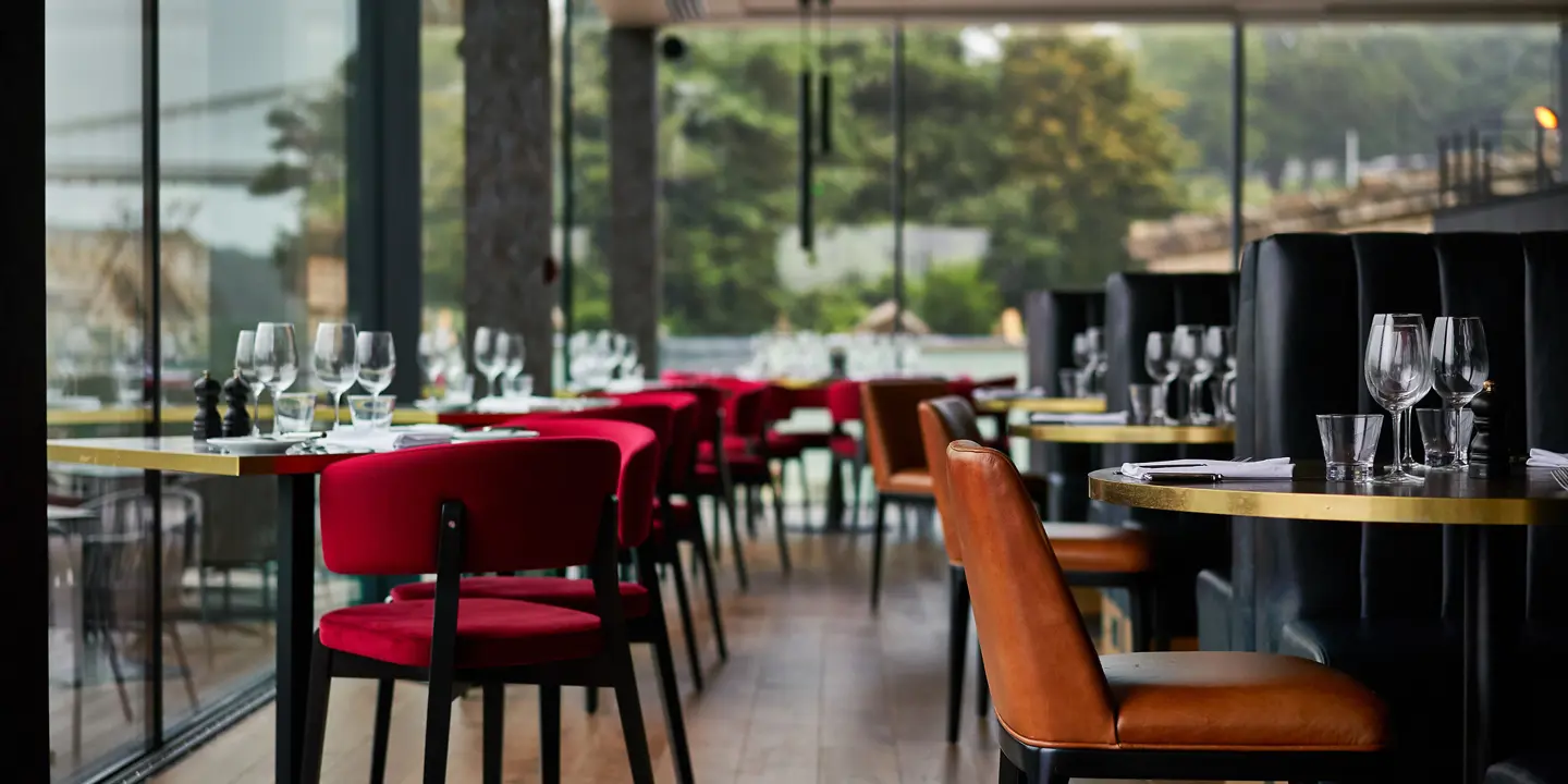 A restaurant featuring numerous tables and chairs.