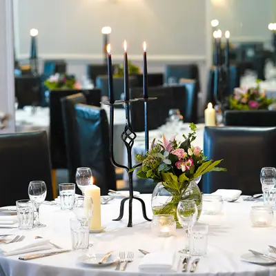 Table set for a formal dinner with candles and flowers.