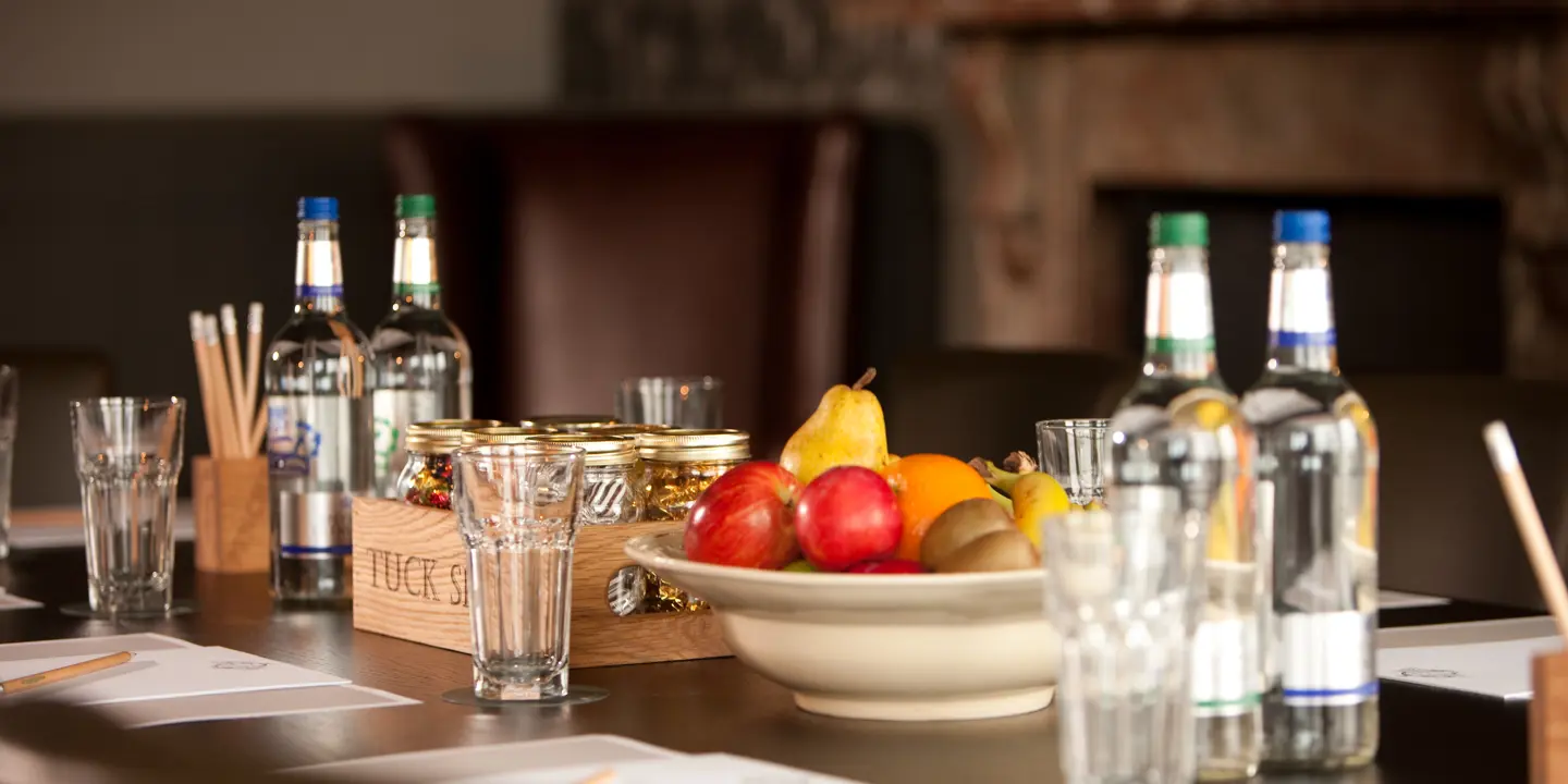 Bowl of assorted fruits and bottles of water placed on a table