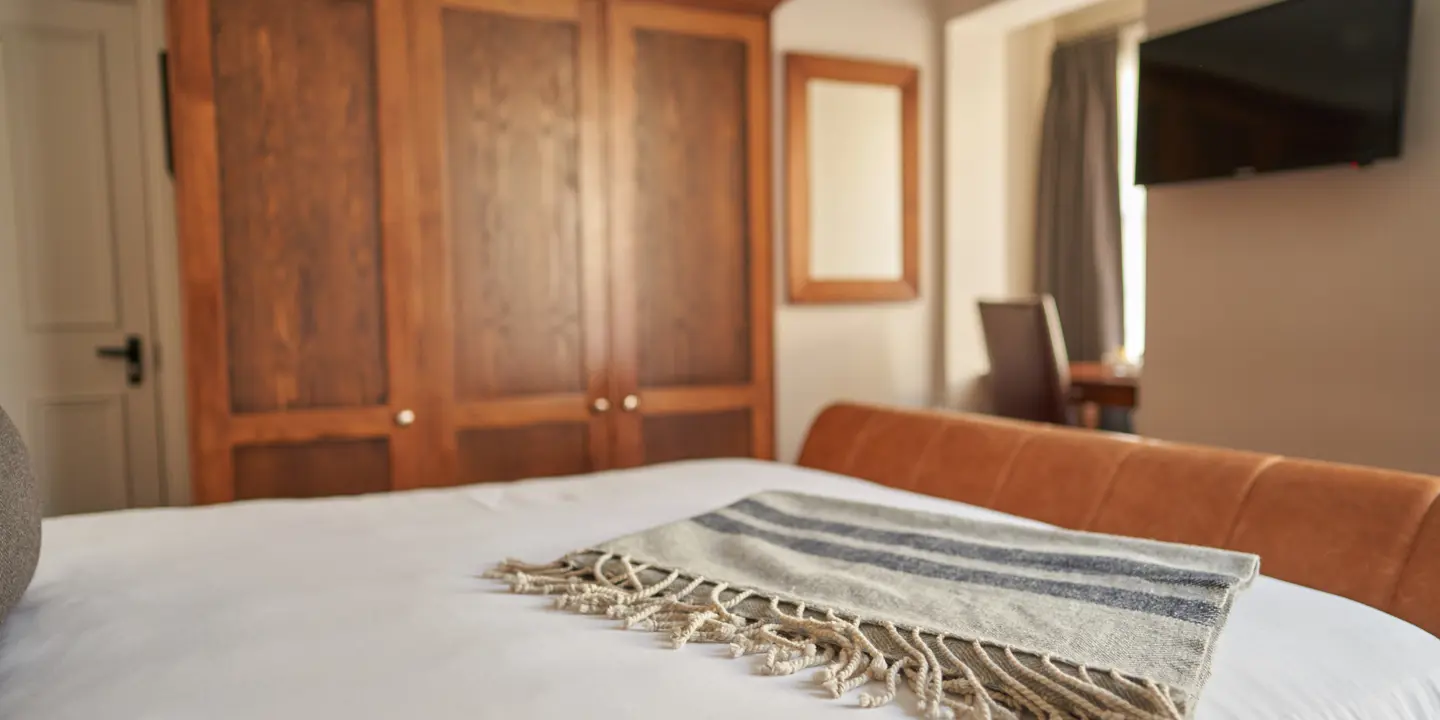 Bed with neatly folded blanket on top